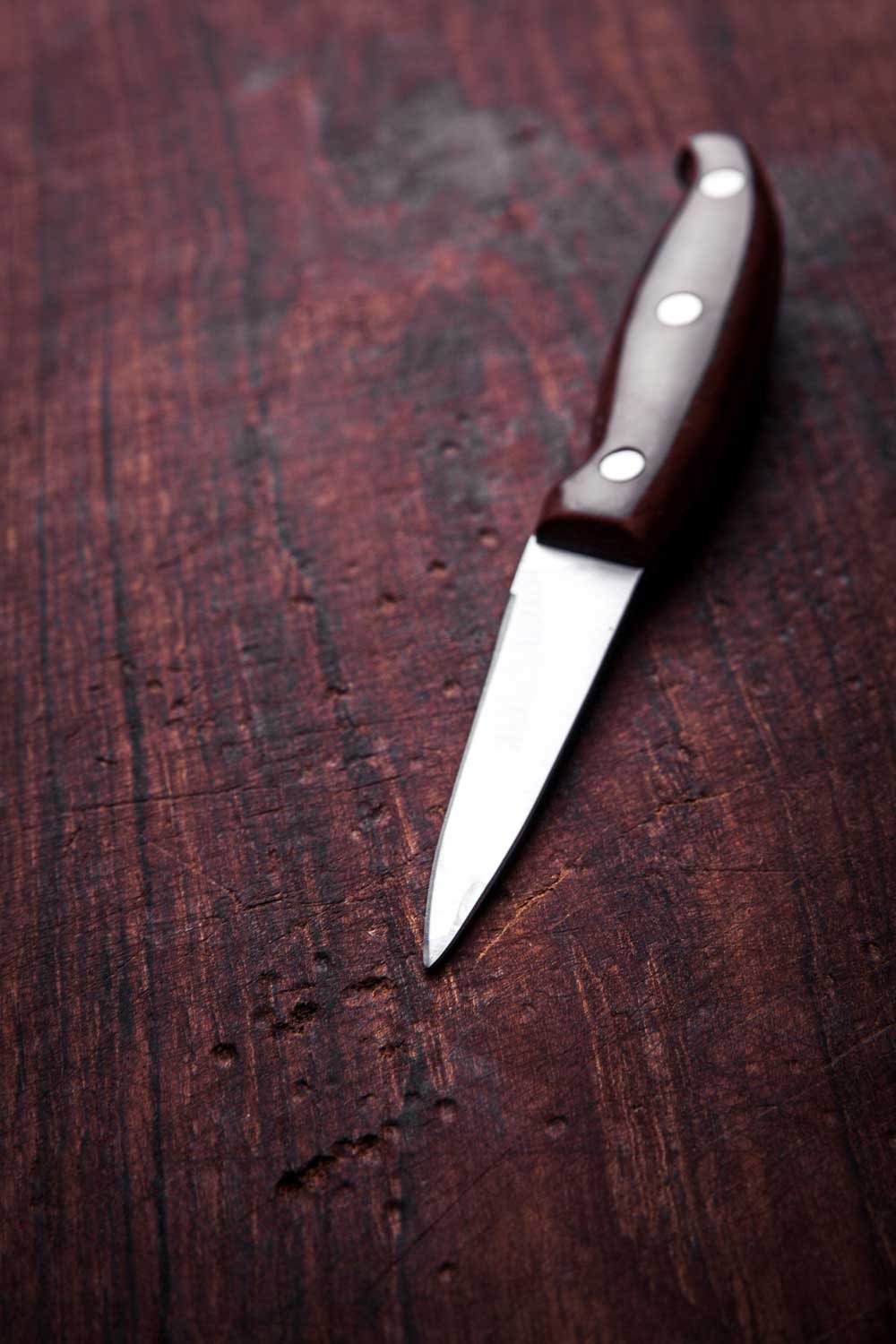 Cuchillo de puntilla en primer plano sobre una mesa de madera 